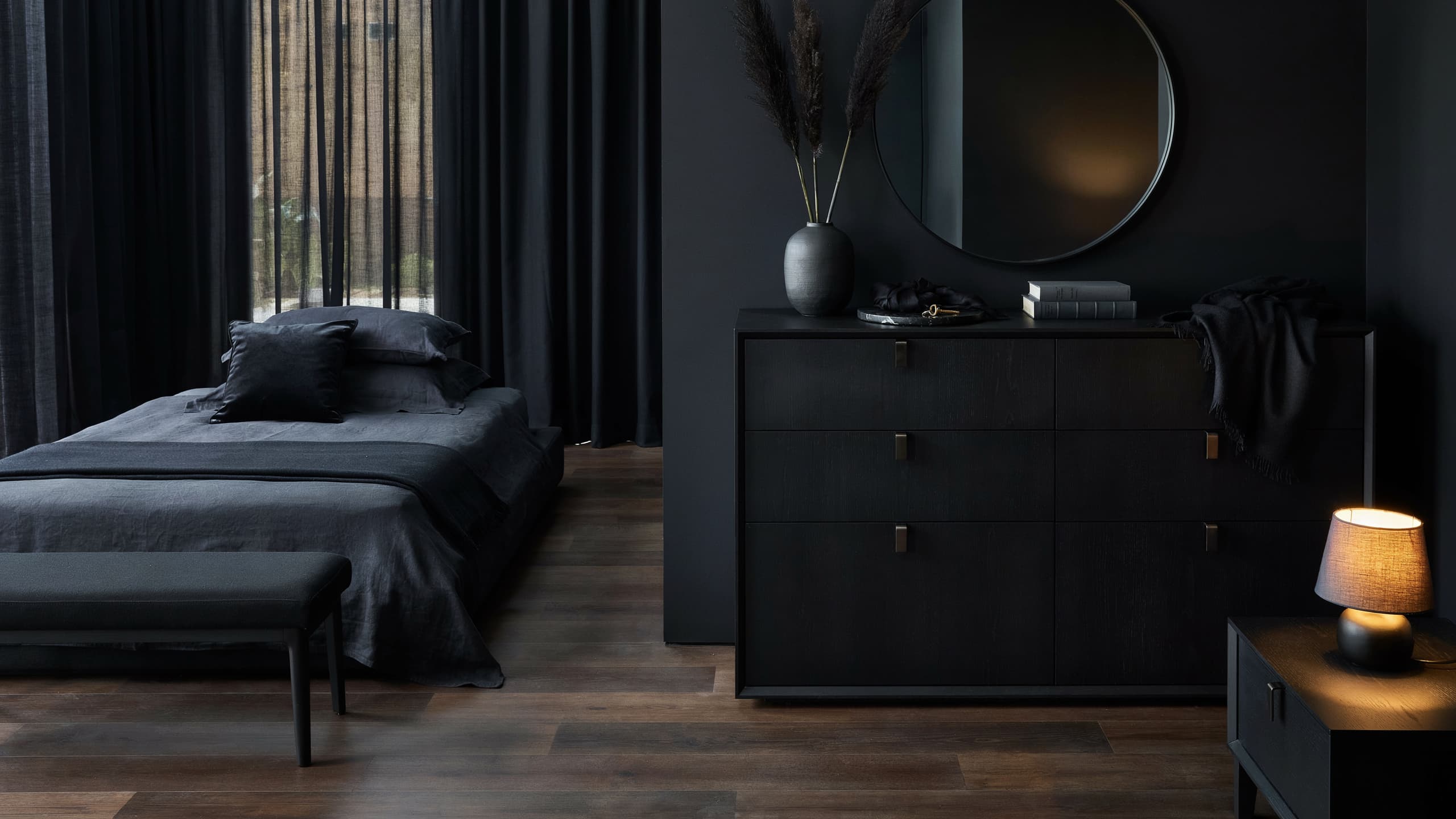 Black bedroom with matte black dresser and matching dark furniture