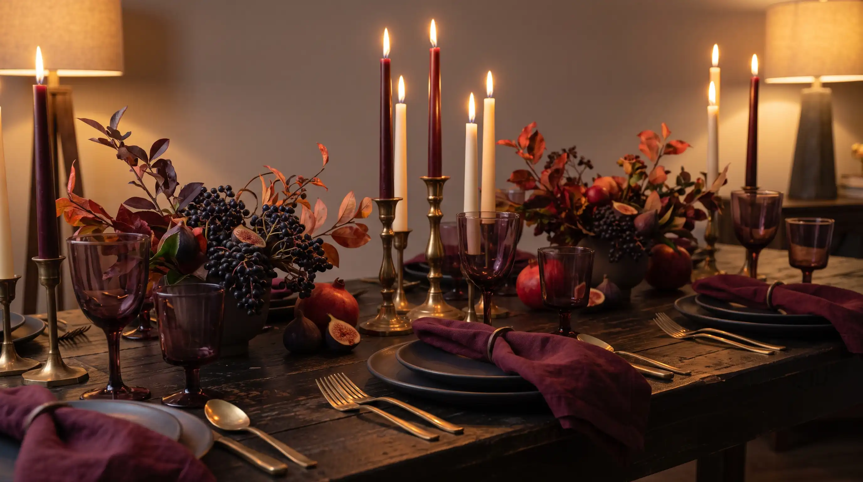 Moody fall table with burgundy linens, plum glassware, brass details, figs, and taper candles