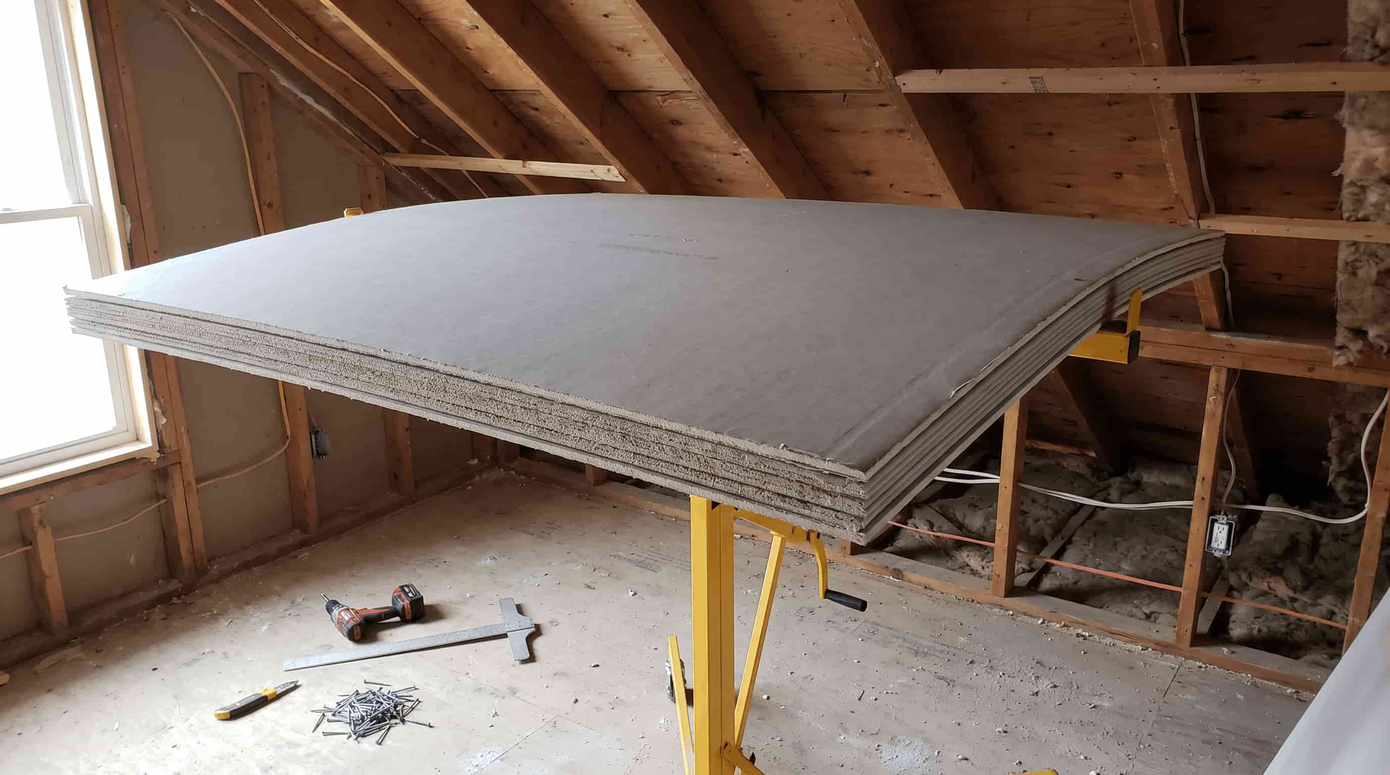 Thicker drywall panel being installed on a ceiling for added support